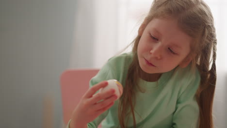 Thoughtful-girl-holds-Easter-egg-colored-with-marbling