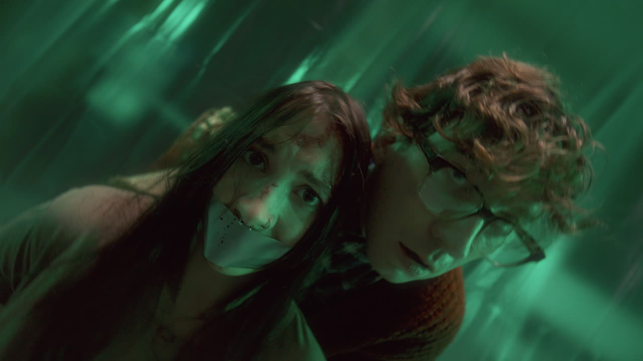 retrato de un maníaco malvado y un rehén asustado en un sótano poco iluminado