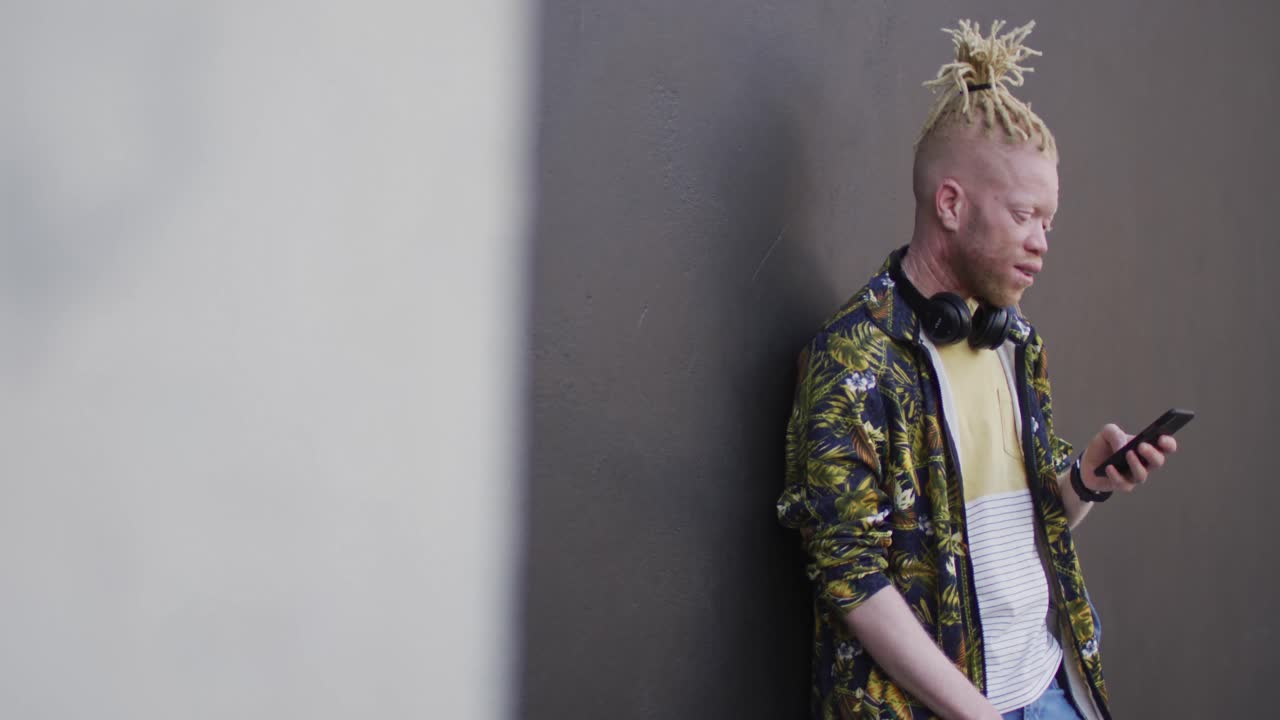 스마트 폰을 사용하는 생각나는 알비노 아프리카계 미국인 남자