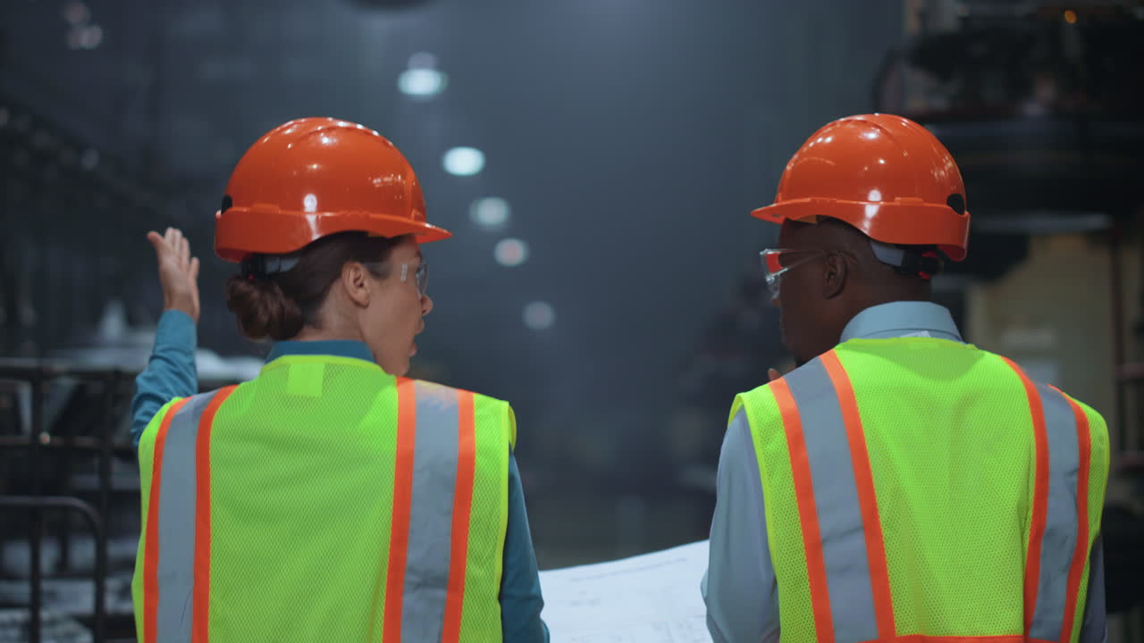supervisores profesionales multiétnicos caminando en el almacén especial de la fábrica.