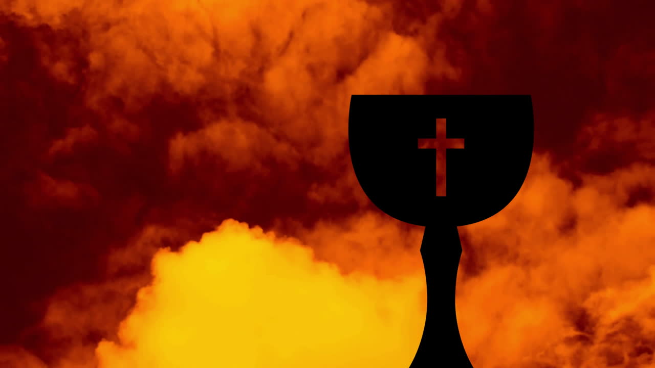 Cross silhouette on chalice with dramatic orange and yellow cloud background