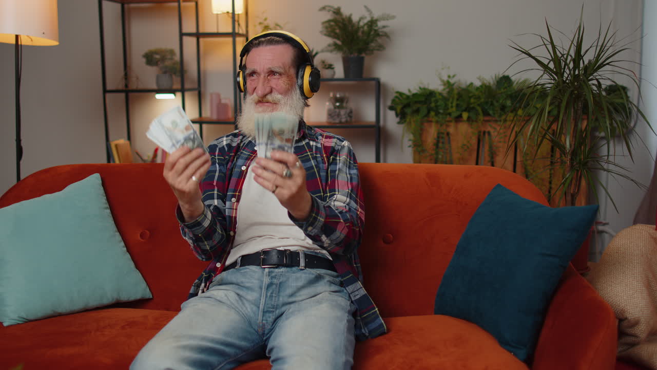 Nonno anziano, ricco e di successo, che ascolta musica e tiene in mano denaro contante, vincita alla lotteria, ricchezza e reddito