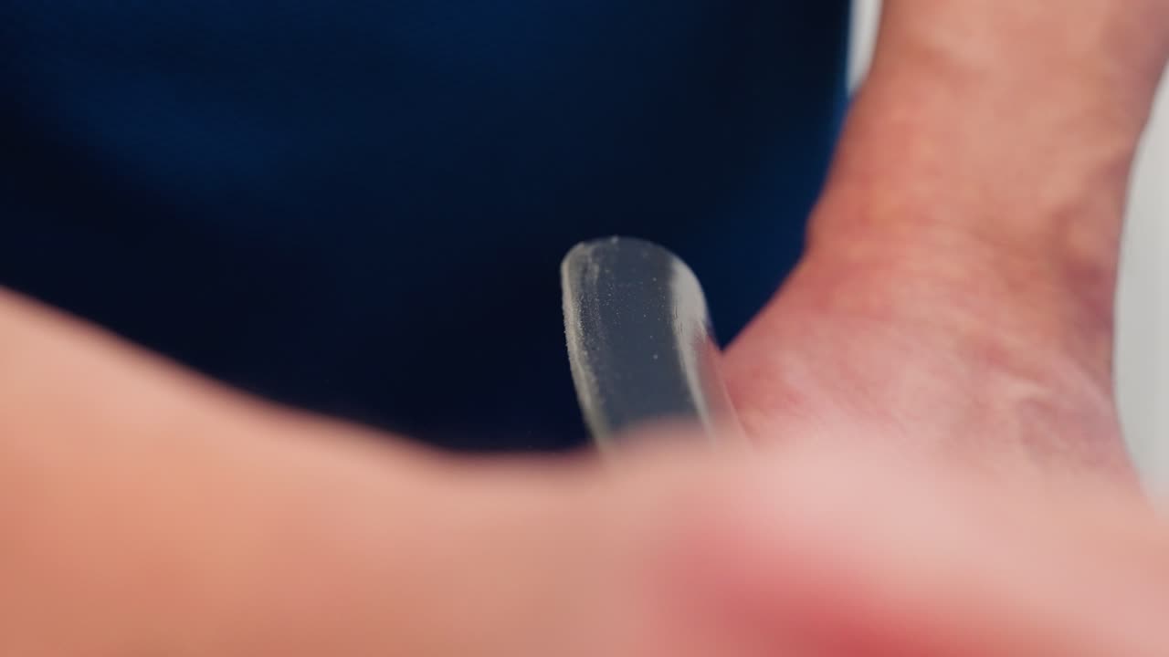 Ultra slow motion close up shows hand sanding wooden chair back with sandpaper