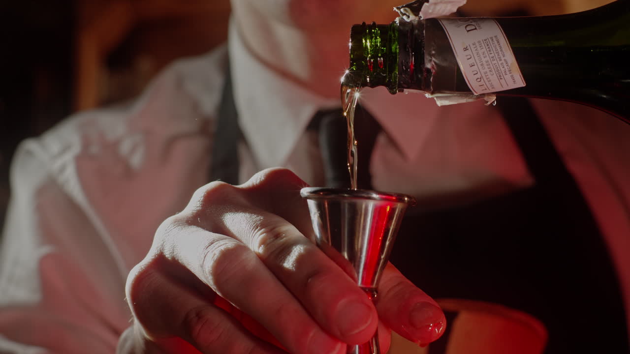Bartender pouring liquor into a measuring cup