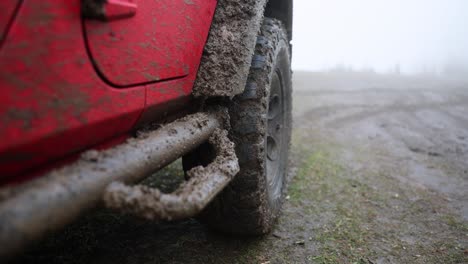 mud-splattered red off-road vehicle