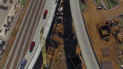 cars driving over busy downtown city overpass and equipment during construction project