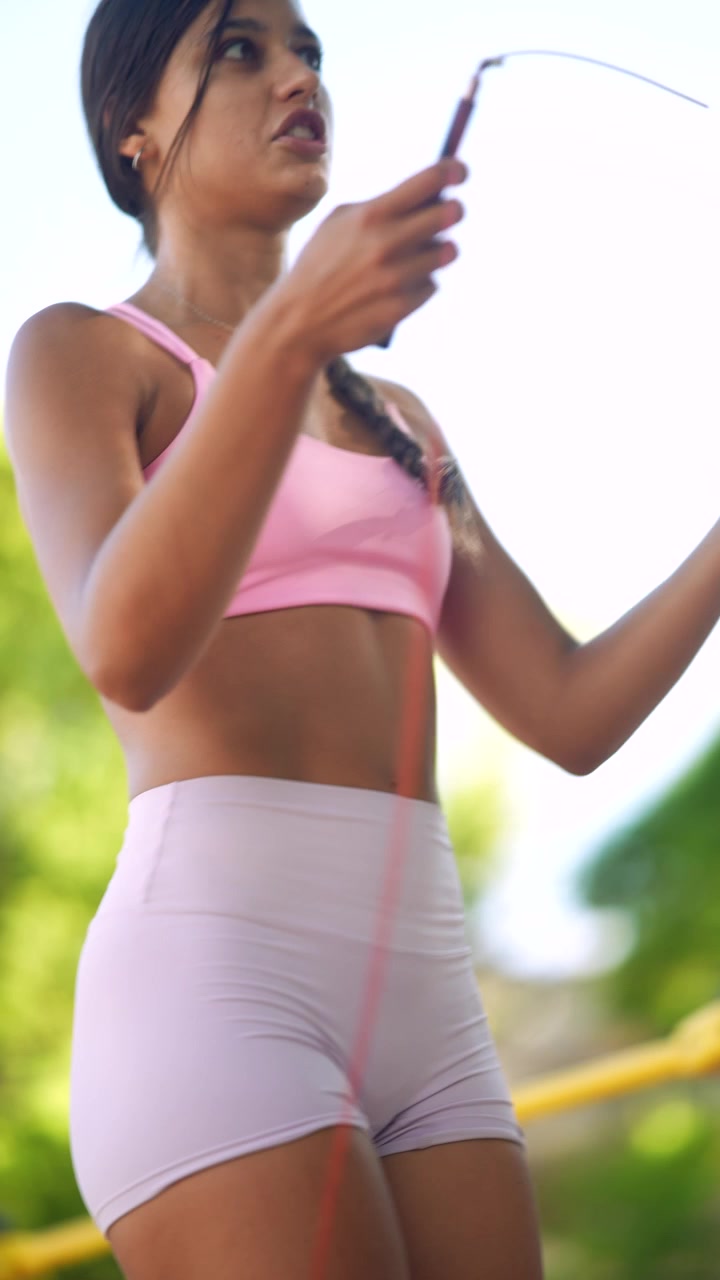 Giovane donna in forma che si allena con la corda all'aperto