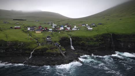 idyllic village on kalsoy island featuring colorful houses, cascading waterfalls, rugged cliffs, and misty hills. serene coastal setting is complemented by lush green landscapes and dramatic seascapes