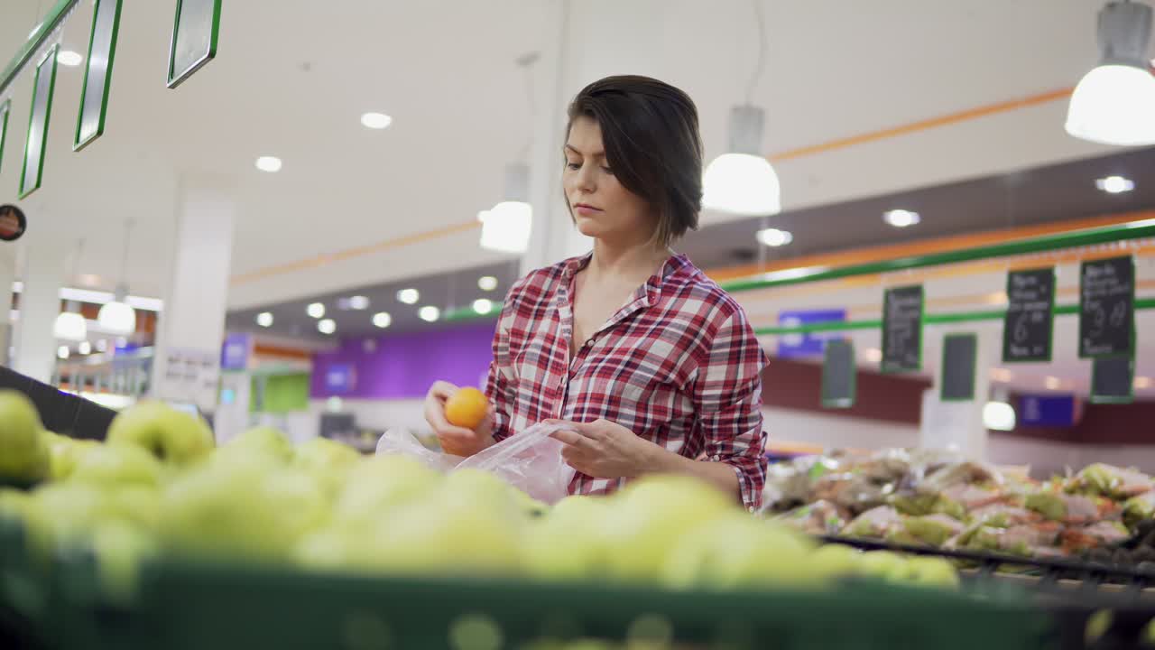 hermosa mujer comprando naranjas en el supermercado