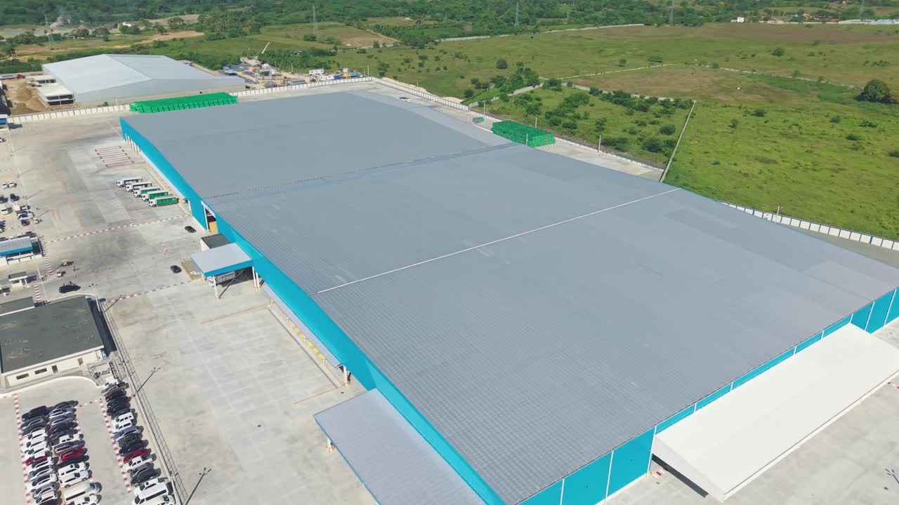 Parking cars on area of logistics transformation hub of Dominican National brewery in Dominican Republic. Sunny day in summer. Aerial orbit wide shot