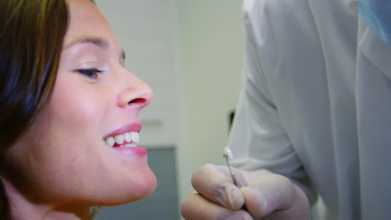 dentista examinando paciente do sexo feminino com pantalões de dentes