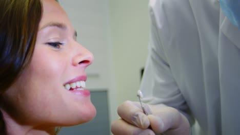 dentist examining female patient with teeth shades