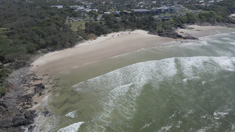 Olas-Salpicando-En-La-Orilla-Y-El-Acantilado-En-La-Playa-De-Cabarita,-Nueva-Gales-Del-Sur,-Australia---Retroceso-Aéreo