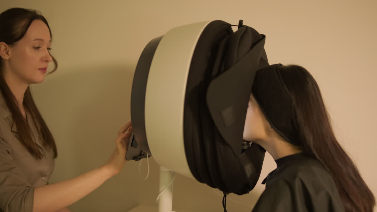 Cosmetologist Operating Skin Analysis Machine for Client's Facial Examination