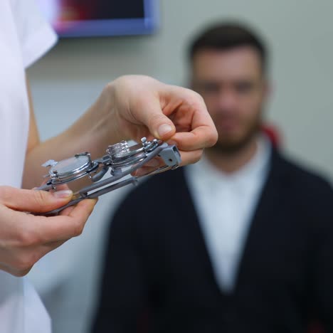 ophthalmological trial frame and test glasses in woman's hands. eysight correction. young man on blurred background