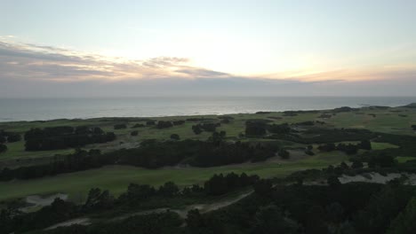 aerial view of sunset above pacific ocean and bandon dunes golf resort in oregon, usa