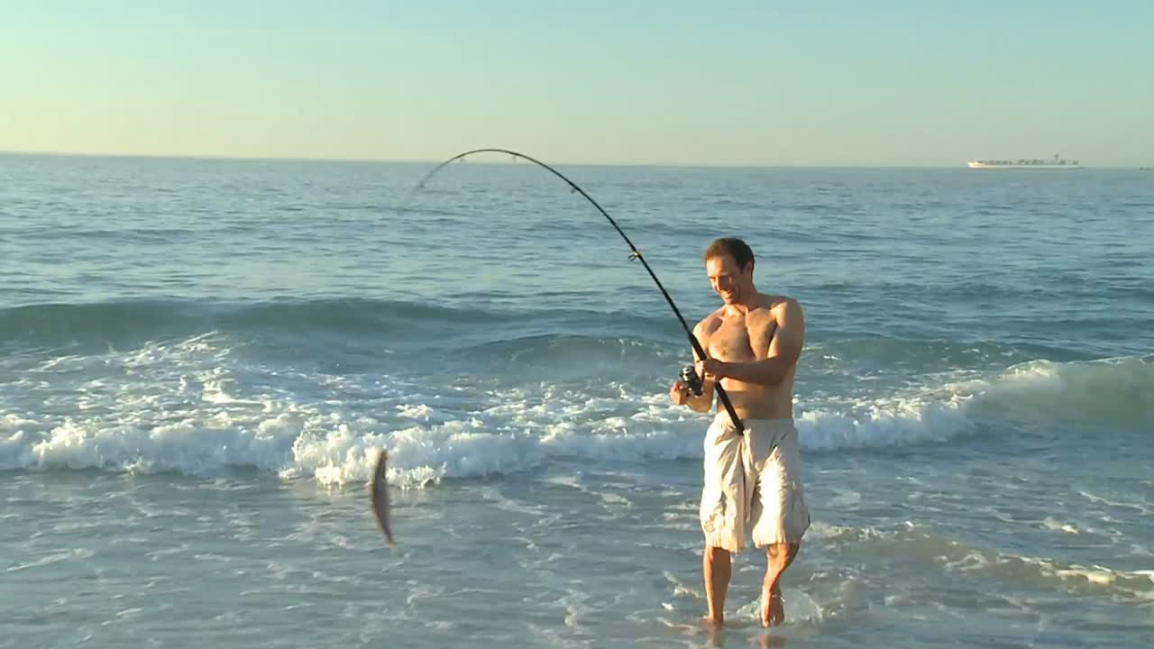 hombre pescando en la playa