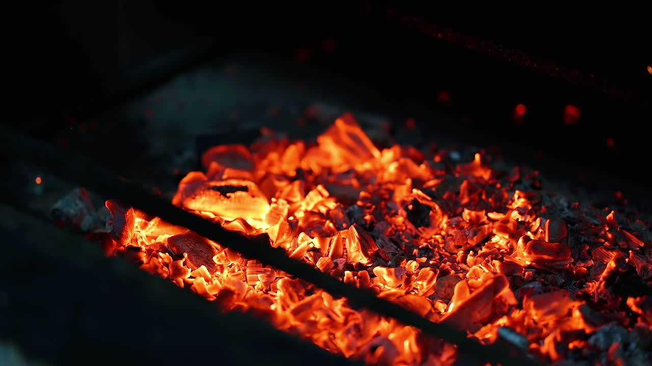 Burning up logs on campfire. Detailed motion of fire on black wood smoldering. Wooden logs in vivid flame. Close-up