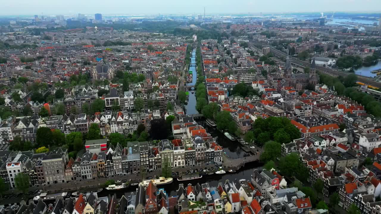 Drone flies forward over homes and canal in Amsterdam (60fps)