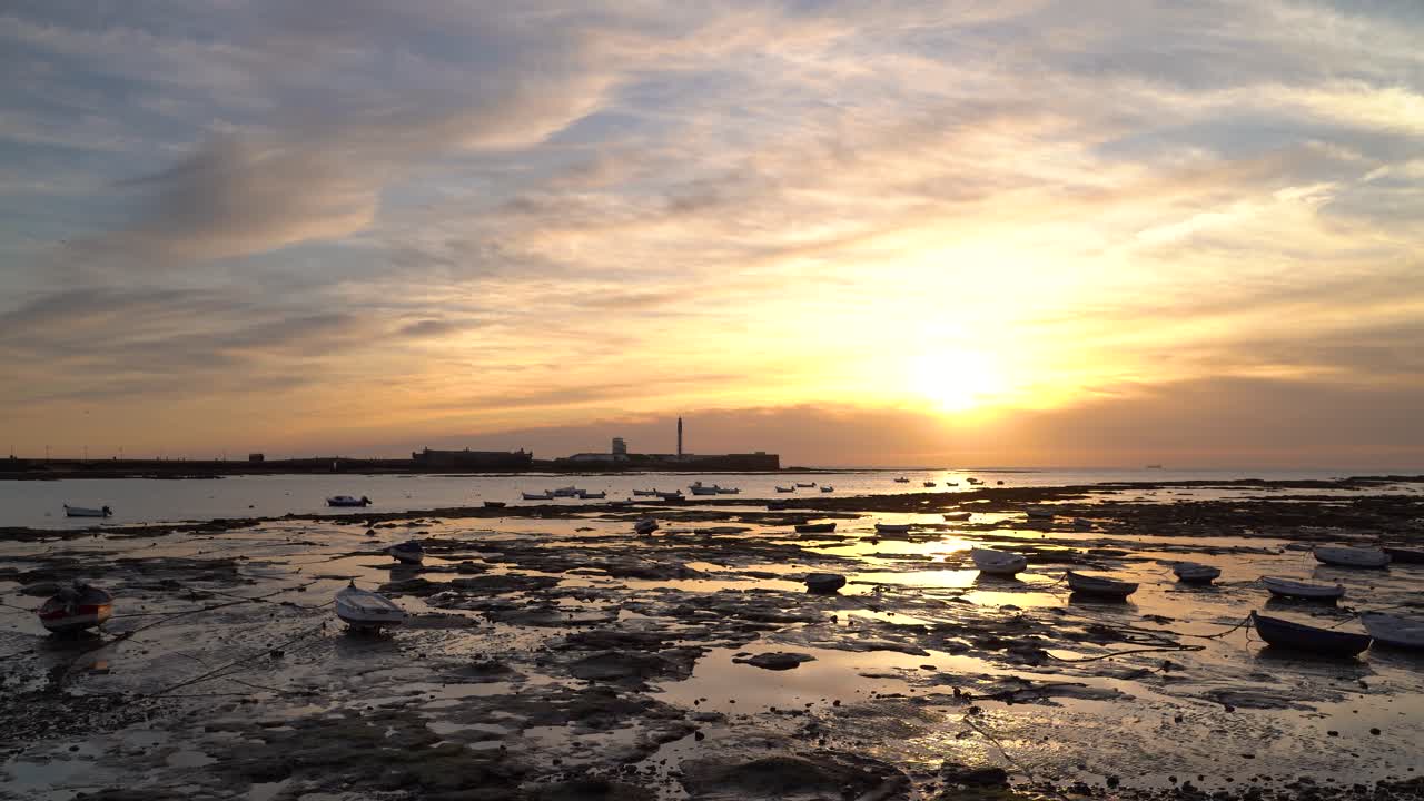썰물 때 바다의 멋진 일몰과 어선 실루엣