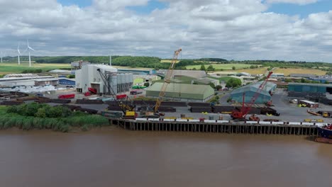 aerial footage of raw material offloading and heavy equipment at industrial dockyard river trent uk