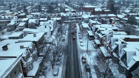 Rising-drone-shot-of-snowy-housing-area-with-flurries