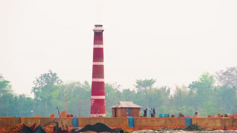 Red-chimney-of-brick-factory,-Asian-workers-work-hard-in-heat