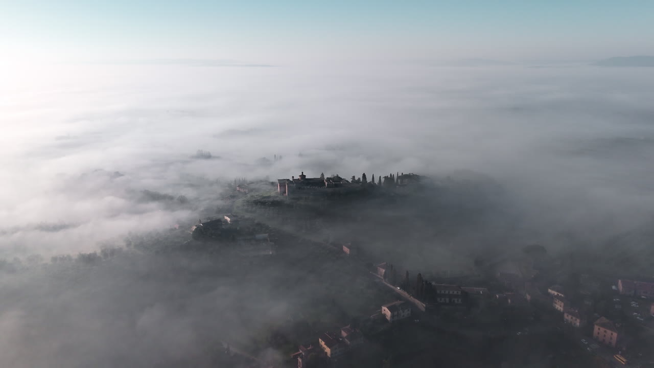 Veduta aerea dei dintorni nebbiosi di Siena in Toscana, che evoca calma e meraviglia.