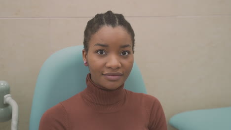 niña paciente mira a la cámara antes de un examen médico