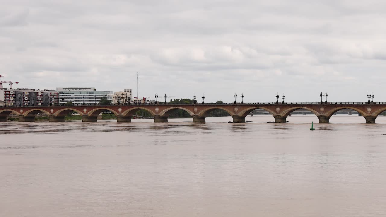 다리는 강을 가로지르고, 배경에는 도시 풍경이 있습니다.