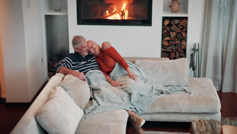 elderly couple cozying up by the fireplace