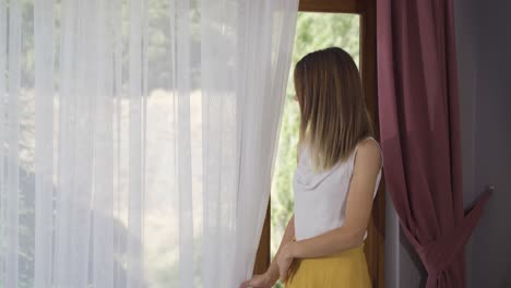 una mujer mirando por la ventana.