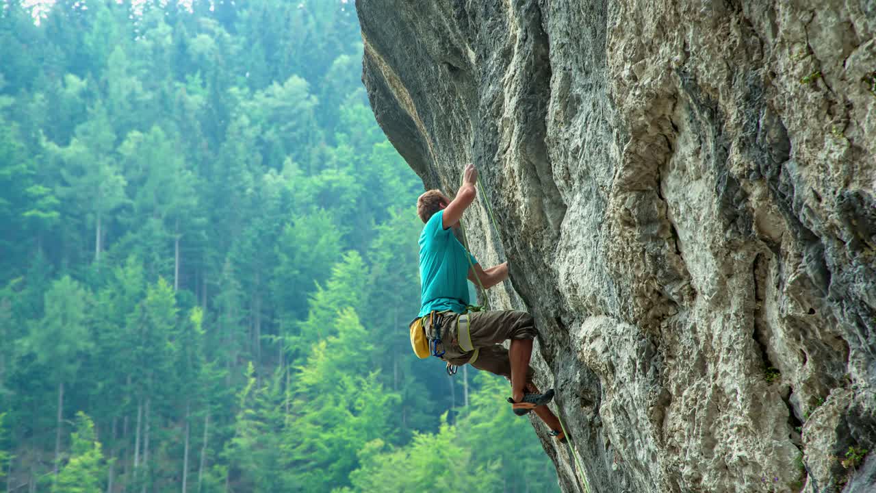 escalador haciendo un movimiento, joven en forma escalando una ruta deportiva difícil