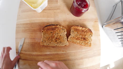 Point-of-view-of-man-preparing-toast-and-jam