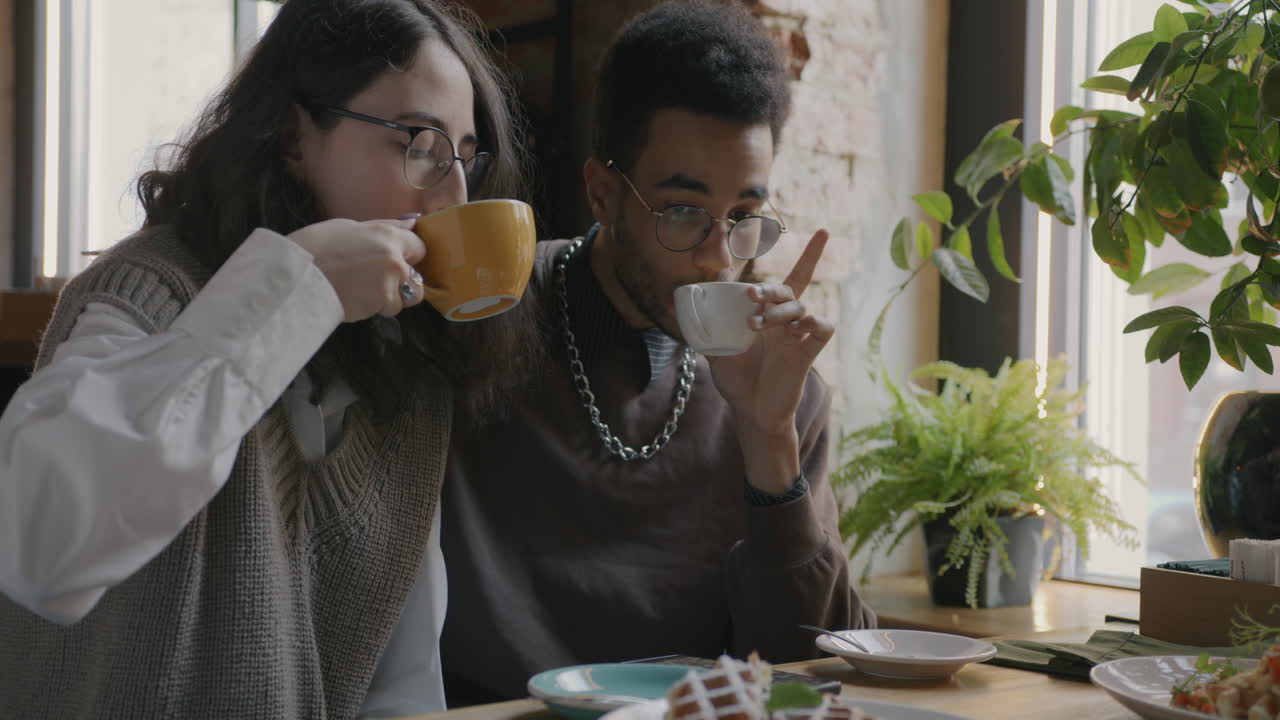 커플 이 카페 에서 커피 와 대화 를 즐기고 있다