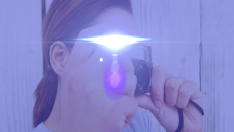 punto de luz contra una fotógrafa afroamericana haciendo clic en imágenes con una cámara digital