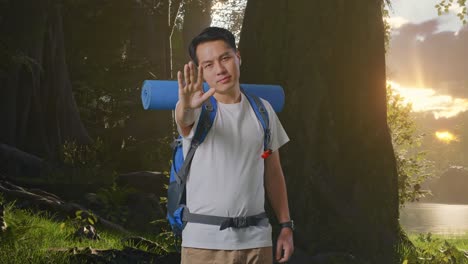 man hiking in forest giving stop gesture
