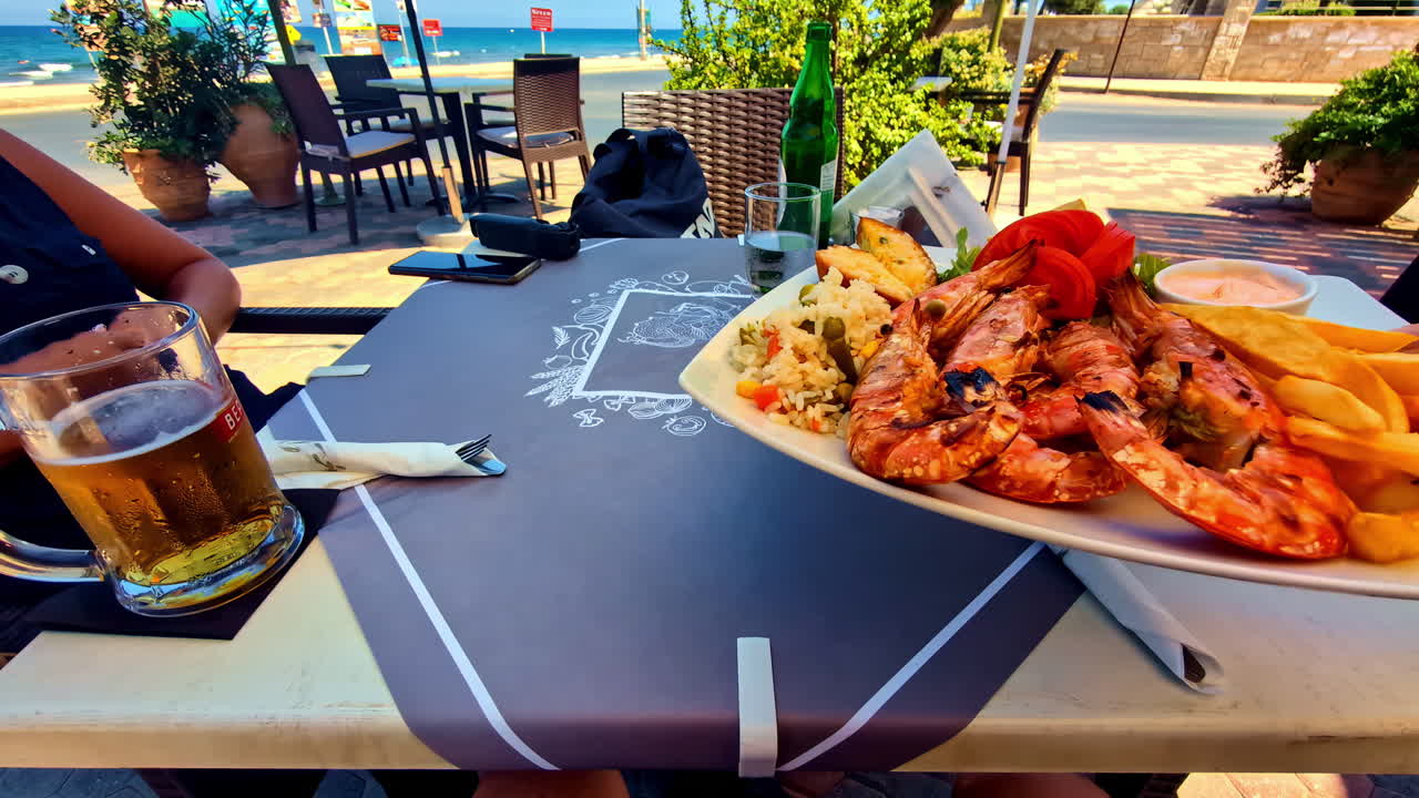 Waiter leaving a tray of shrimp on the table. Fisheye angle