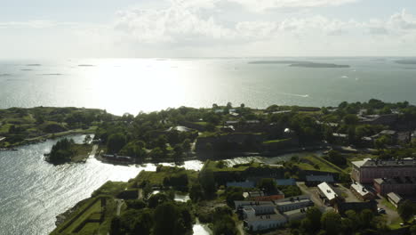 Aerial,-rising,-drone-shot-overlooking-buildings-on-the-Susisaari-and-Iso-Mustasaari-islands,-at-the-Suomenlinna-fortification,-sunny,-summer-day,-in-Helsinki,-Finland