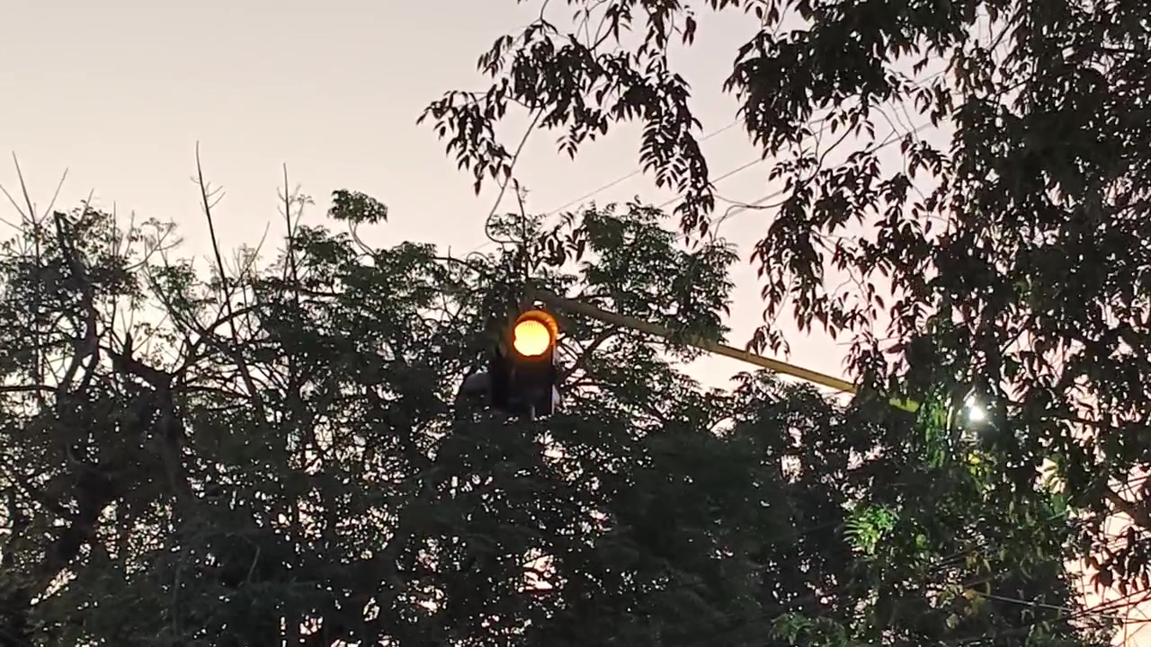 Lampu Lalu Lintas Kuning Berkedip saat Matahari Terbenam