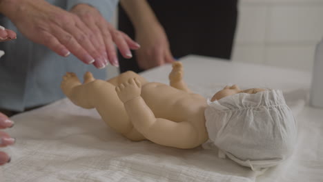 teacher and student taking care of toy baby