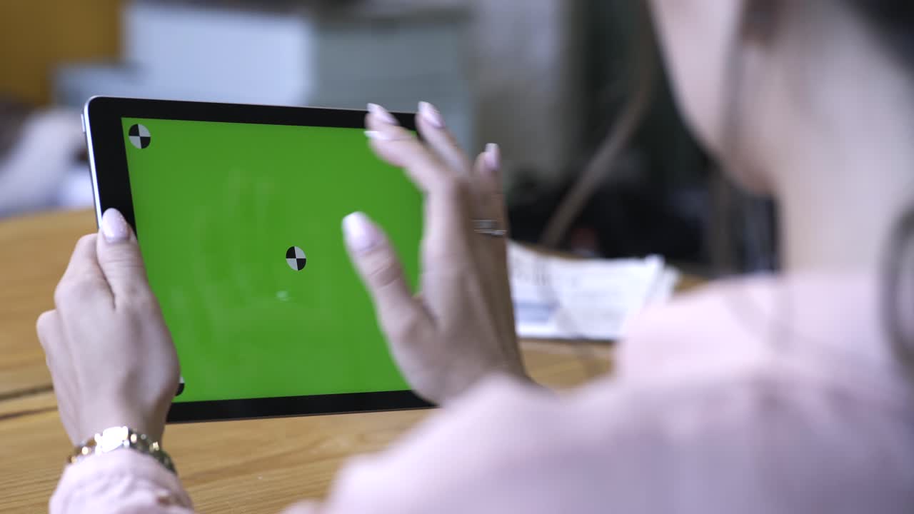 mujer usando una tableta con pantalla verde