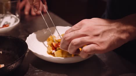 Cook-in-the-kitchen-of-an-Italian-restaurant-puts-the-fried-chicken-and-red-tomato-on-the-plate-with-pasta