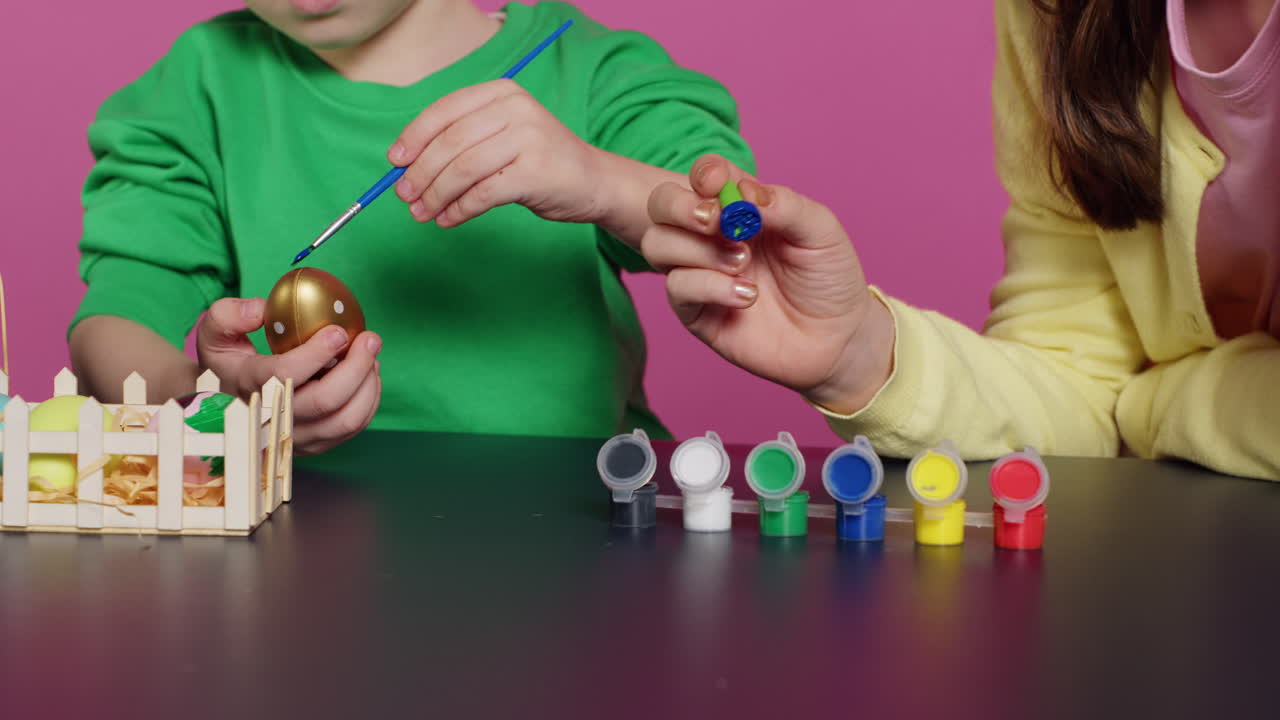 niños lúdicos pintando huevos con acuarela y pinceles