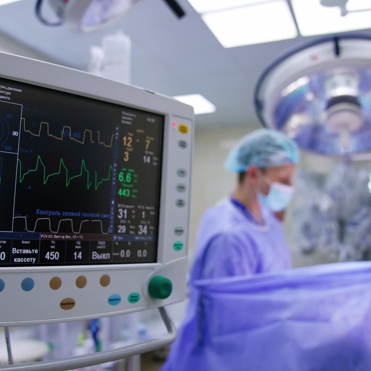 Schermo nero di un ventilatore polmonare con curve in movimento. Dispositivo che monitora le condizioni del paziente durante l'intervento. Medici che lavorano sullo sfondo.