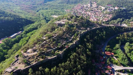 Wide aerial drone push-in revealing the full Tsarevets hill and fortress complex in Veliko Tarnovo, Bulgaria.
