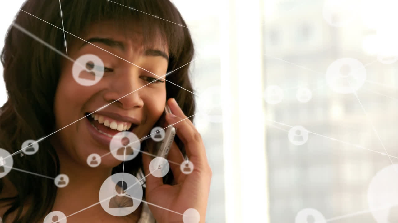 animación de una red de iconos de perfiles contra una mujer afroamericana hablando en teléfono inteligente en la oficina
