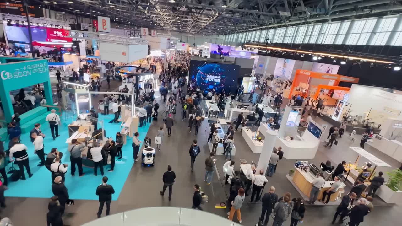 High-angle video of a bustling tech expo, showcasing various booths and attendees