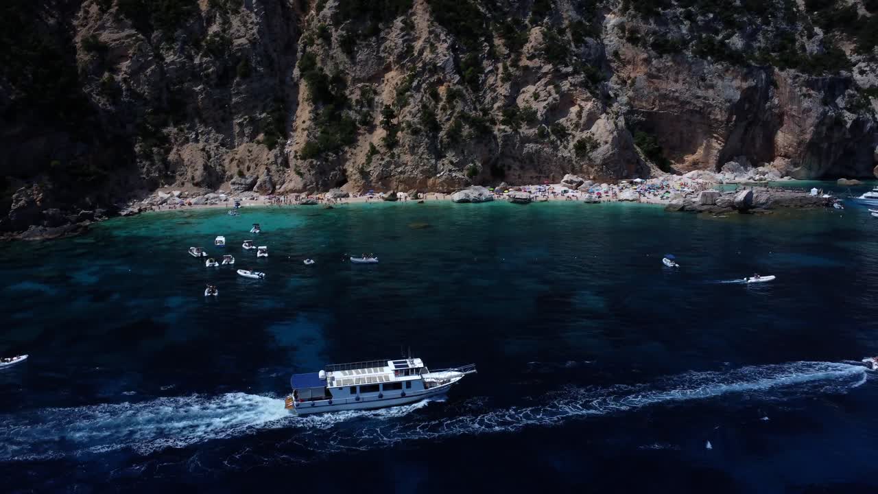 Tourist boat unveiling an overcrowded beach in sardinia