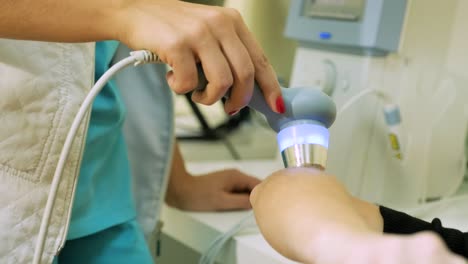 médico fisioterapeuta realiza una cirugía en la mano de un paciente